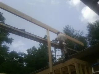 Carpenter setting a ridge beam over a new addition frame — Ice Dam Removal by Roofing Brothers in Sophia