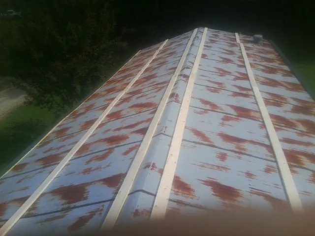 Rusted metal roof panels with new wood purlins before replacement — Storm Damage Roof Repair in Sophia by Roofing Brothers