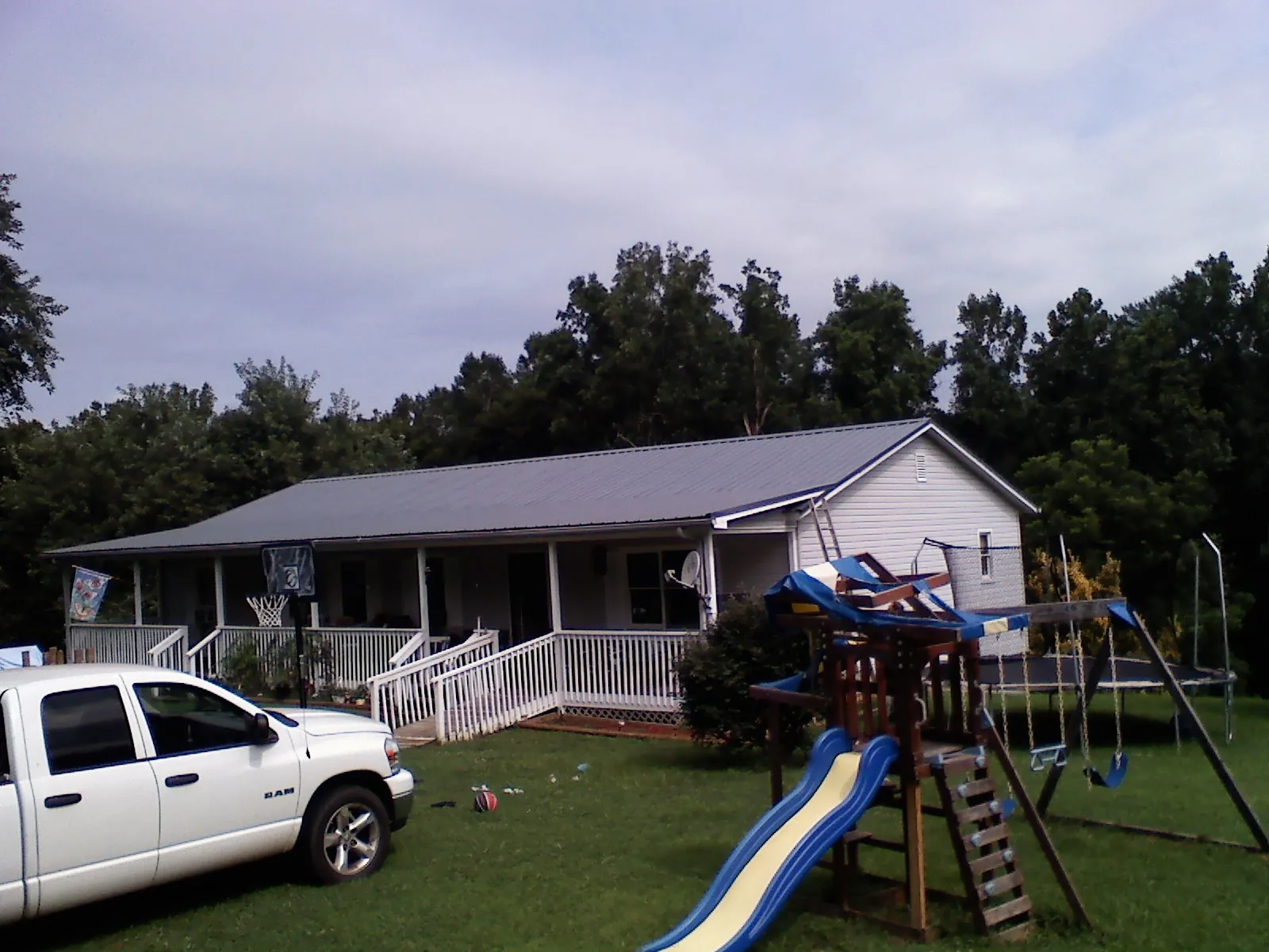 Dark metal roof on a country home with a full length front porch in Sophia