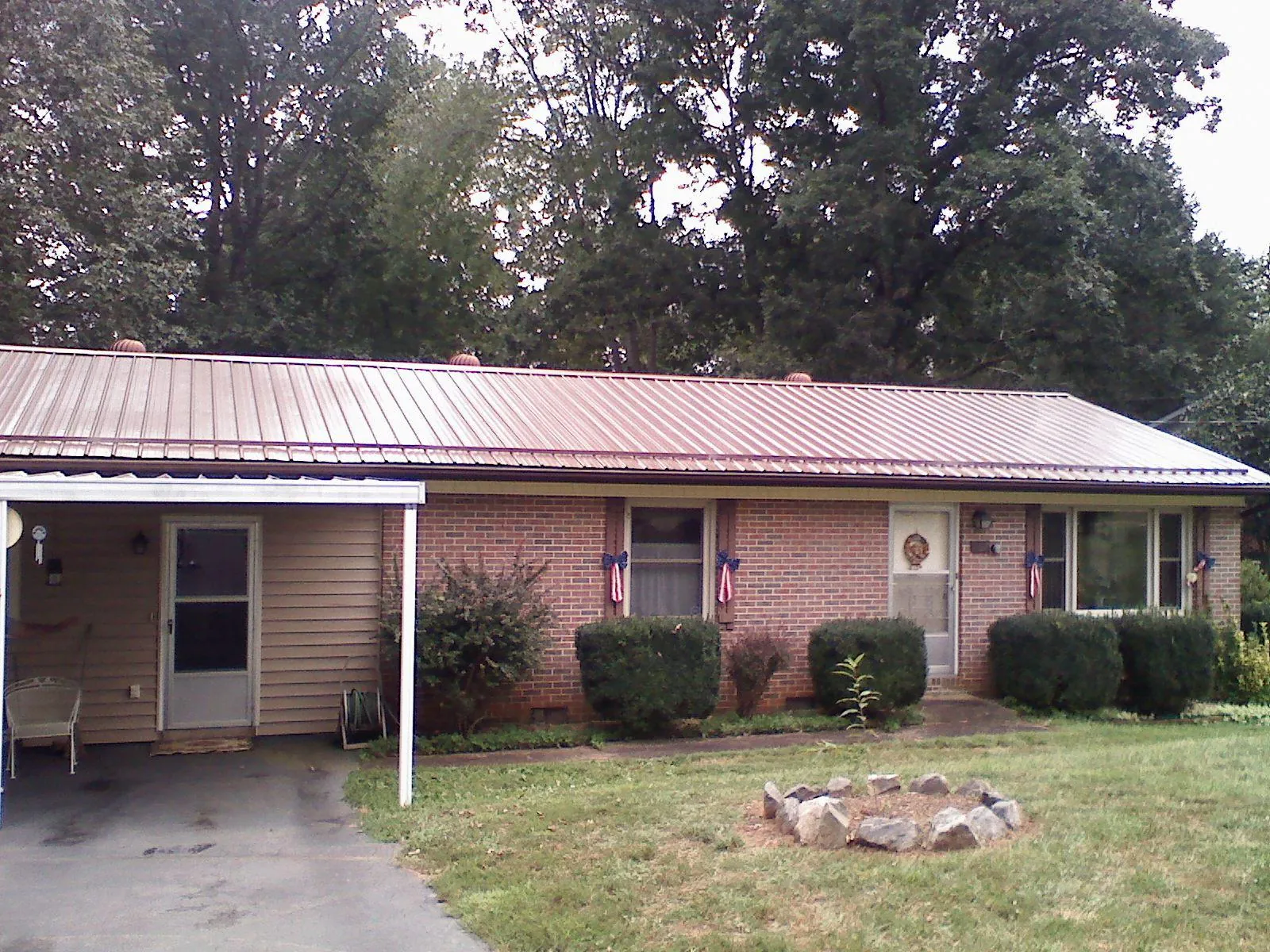 Bronze metal roof and carport on a brick ranch home — Roof Repair work by our crew in Sophia